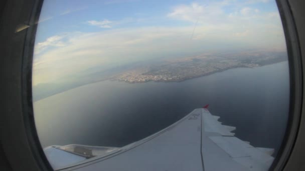 Avião virando a cidade - Olhando para a janela do avião . — Vídeo de Stock