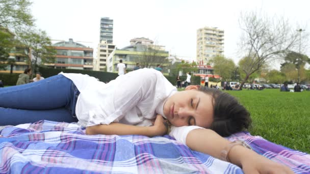 Niña durmiendo en la hierba en el parque — Vídeos de Stock