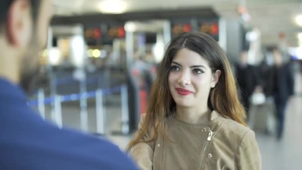 Jovem e mulher está flertando - Primeiro encontro no aeroporto. Ela dá-lhe o número de telefone. — Vídeo de Stock