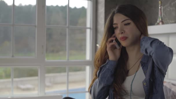 Jeune femme bouleversée parle au téléphone dans la chambre — Video