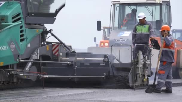 TBILISI - GEORGIA 15 Junho 2016 - Clipe de equipamento pesado máquina de assentamento de asfalto soltando alcatrão blacktop — Vídeo de Stock