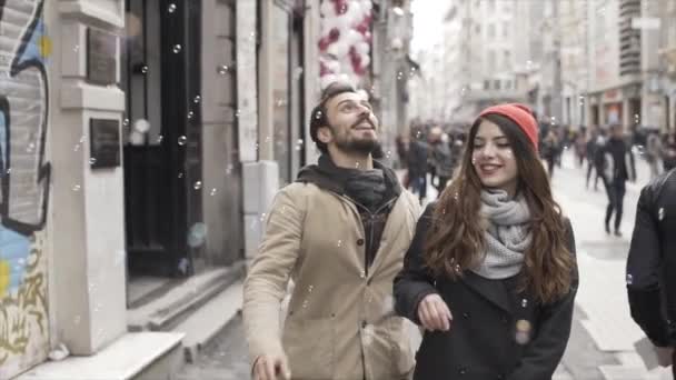 Молода пара грає з бульбашками на вулиці - повільний рух — стокове відео