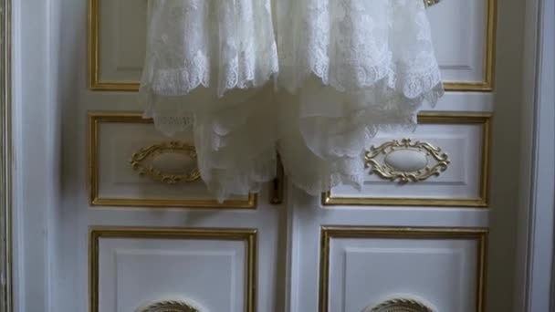 Vestido de novia colgando de la puerta — Vídeos de Stock