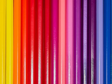 Dikey olarak dizilmiş renkli kalemlerin canlı ve çeşitli spektrumlarını yakalayan çarpıcı, aşırı yakın çekim. Bu soyut desen, her kalemin zengin dokularını ve yoğun tonlarını gösterir, dinamik ve görsel olarak bağlayıcı bir arka grup oluşturur.