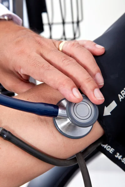 Médico midiendo la presión arterial a un paciente —  Fotos de Stock