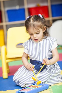 Küçük kız bir ksilofon çalmaya