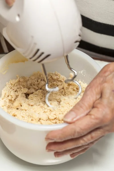 Misturando massa de biscoito com um misturador de mão — Fotografia de Stock