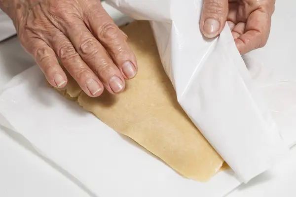 Doblar la masa de la galleta con una bolsa de plástico — Foto de Stock