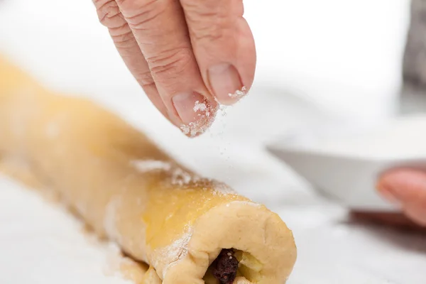 Strö socker över de rullade upp strudel degen — Stockfoto