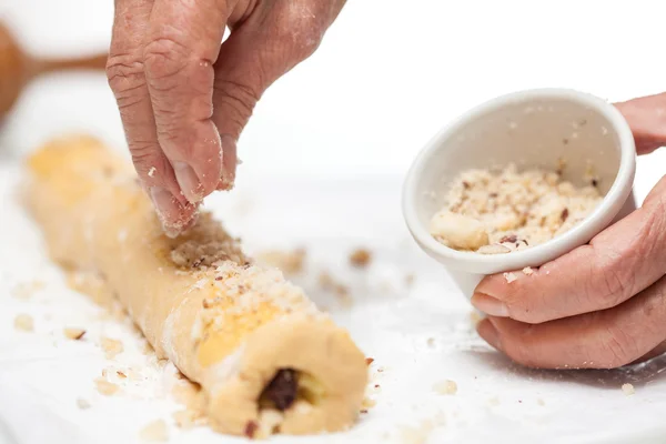 Nüsse über den aufgerollten Strudelteig streuen — Stockfoto