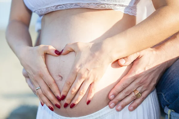 Paar op het strand te wachten voor hun baby - 28 weken — Stockfoto