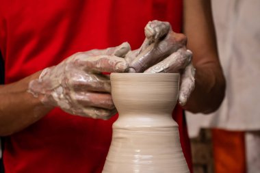 Kolombiya 'nın Cundinamarca bölgesinde bulunan Raquira şehrindeki geleneksel bir fabrikada çömlekçiler çarkında seramik makaleler yapan adam.