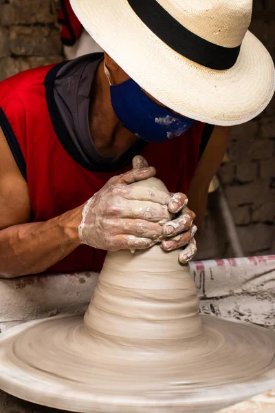 コロンビアのCundinamarcaの部門にあるRaquira市の伝統的な工場で陶芸家ホイール上のセラミック記事を作る男 — ストック写真
