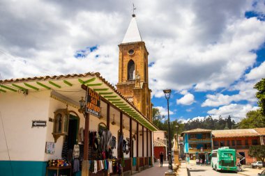 RAQUIRA, COLOMBİA - Şubat 2021. San Antonio kilisesinin kulesi ve Raquira şehir meydanının etrafındaki sokaklar. Saksılar şehri, Kolombiya
