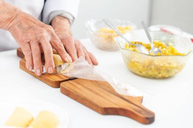 Kıdemli bir kadın Kolombiya 'daki El Valle del Cauca' dan geleneksel bir yemek olan böreği kapıyor ve kesiyor.