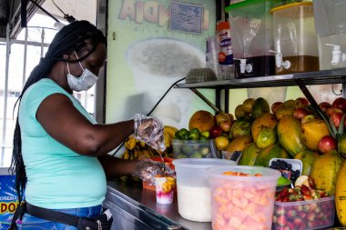 CALI, COLOMBIA - SEPTEMBER, 2021: Kolombiya 'nın Cali şehrinde çikolatalı buzlu geleneksel tatlı su buzunu hazırlayan ve satan kadın