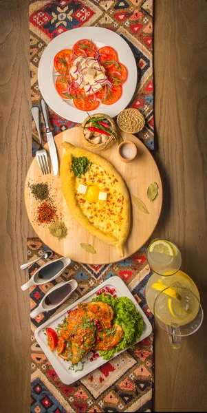 Pain plat géorgien et salade de poulet et tomates à l'ail, fromage de chèvre et épices — Photo