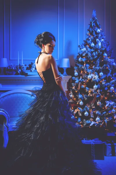 漂亮的模特女孩附近与礼物的圣诞树圣诞前夜. — 图库照片