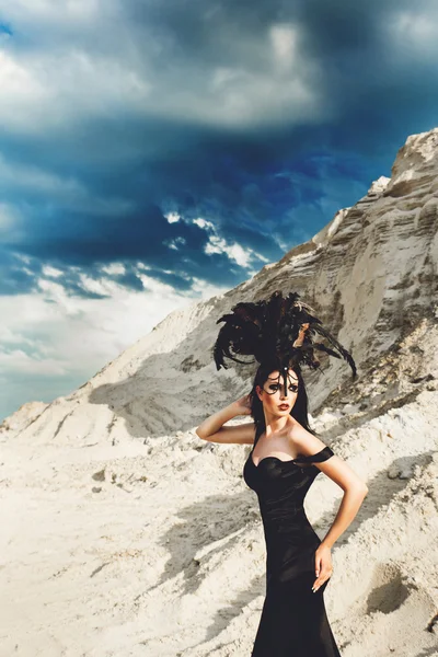 Beautiful girl in black dress with train and hat with feathers — Stock Photo, Image