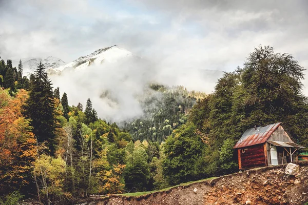 Little house on the cliff by the river in the Caucasus mountains — Stock Photo, Image