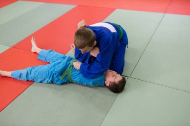 Koçların önünde iki genç sporcu judo yeteneklerini sergiliyor..