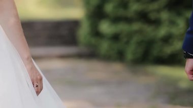 Yaz parkında el ele tutuşan genç bir çift. Genç gelin ve damat için düğün günü