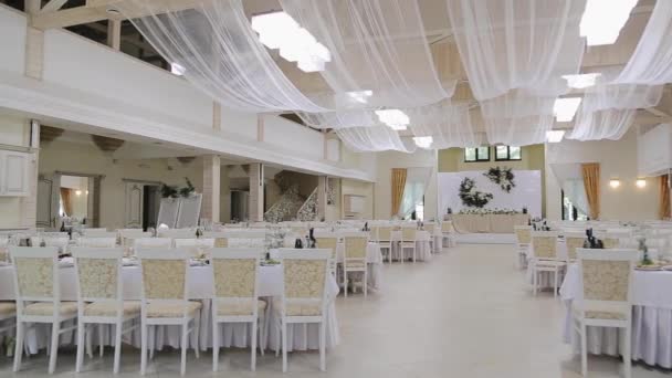 Interiér výzdoby svatební síně připraven pro hosty. Stoly na svatební hostině. Svatební dekorace. Svatební výzdoba v hodovní síni.