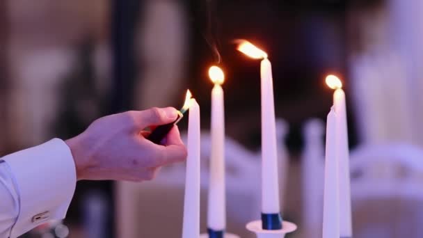 Mãos fechadas de garçom acendendo velas em restaurante elegante. Conceito de jantar romântico — Vídeo de Stock