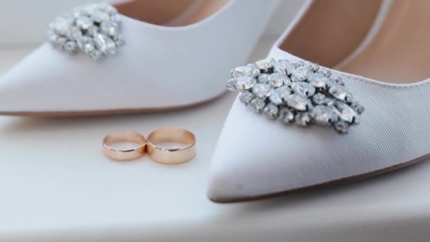 Evlilik yüzükleri ve gelinlik ayakkabıları. Bir çift evlilik sembolü. Gelin ve damadın karı koca olma aşkı. Evlilik sembolü — Stok video