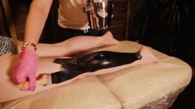 Çamur, bacaklarına ve kalçalarına sürtünüyor. Detoks prosedürleri kavramı