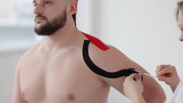 Kinesio Tape Alkalmazó Fizioterapeuta Közeli Képe Sérült Vállon Fekvő Betegekről — Stock videók