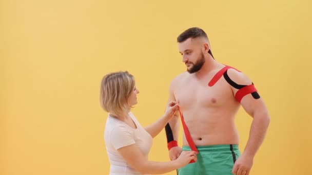 Cinta Terapéutica Hombro Del Hombre Médico Femenino Explicando Atleta Cómo — Vídeo de stock