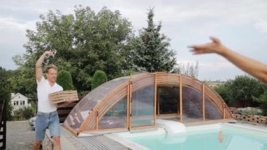 One of friendmates brings a pizza for the others. Meeting of the friends, happy people have lunch together.