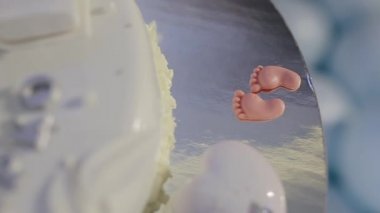 Lezzetli bir doğum günü, vaftiz töreni ya da üstünde uyuyan yeni doğmuş bebeklerle süslenmiş bebek pastası ve altında minik ayaklar. Küçük çocuk için mavi ve beyaz renkli pasta.