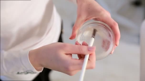 Een Schoonheidsspecialiste Mengt Gezichtsmasker Met Een Borstel Jonge Cosmetoloog Mengt — Stockvideo