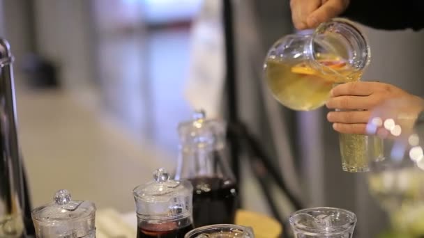 Un hombre vierte limonada naranja en un vaso. — Vídeo de stock