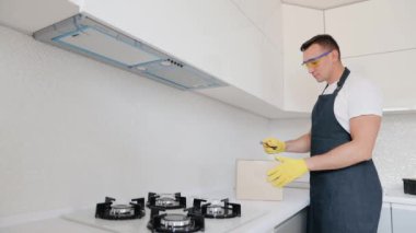 Tamirci, mutfak lavabosuna yeni musluk taktırmak için gerekli parçalarla birlikte teslimat paketini boşaltıyor. Tesisatçı paketleri mutfak musluğuyla açıyor.