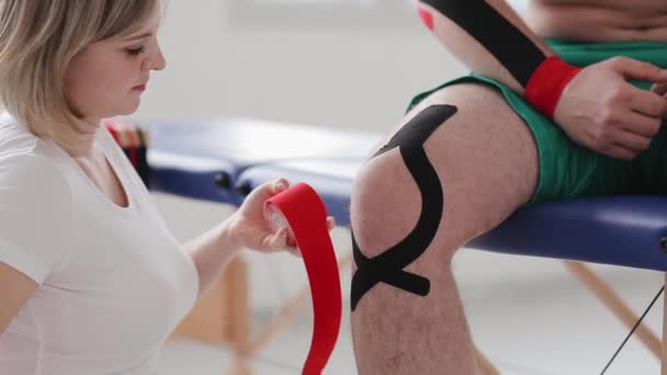 Fysiotherapeut Toepassen Van Red Kinesio Tape Patiënten Been Dokter Gesneden — Stockvideo