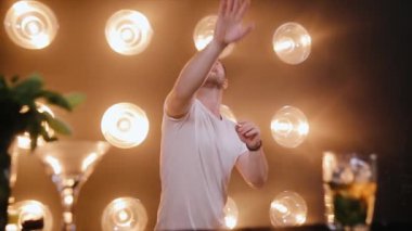 Barmen tezgahın yanında hokkabazlık gösterisi yapıyor. Profesyonel barmen duman ve hafif arka planda şişe cambazlığı yapıyor.