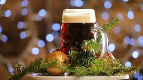 Bière en verre tourner sur le fond avec des lumières vives bokeh. Présentation de bière noire de Noël. — Video