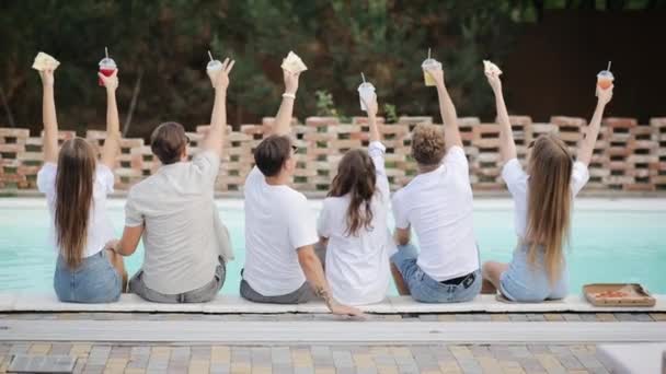 晴れた夏の日にプールに座ってカクテルとグラスをクリックしている友人の風景 プールサイドのパーティーでは 豪華なトロピカルヴィラでドリンクを飲みながら楽しむことができます 友達がカメラを向けると笑顔 — ストック動画