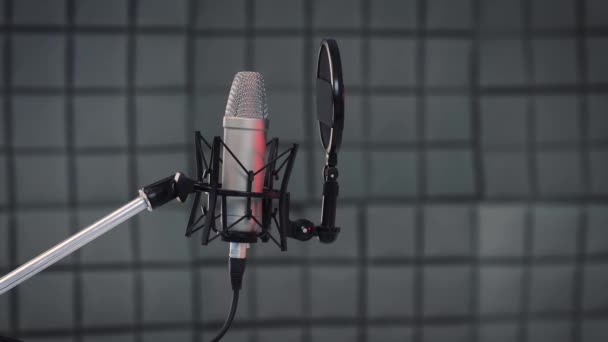 Concepto de grabación. Tracking shot of professional vocal microphone and pop filter for singing or recording a podcast in a bedroom music studio SLIDE RIGHT. — Vídeo de stock