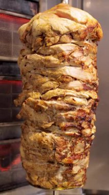 Dikey bir rostoda fırında tavuk eti pişirmek, shawarma ya da doner kebap hazırlamak, popüler sokak yemekleri. Terbiye edilmiş tavuk eti şişte yavaşça kızarır ve hızlı bir yemek için lezzetli katmanlar oluşturur.