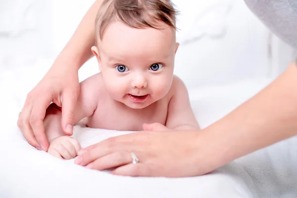 A cute little naked baby on the white wall. — Stock Photo, Image