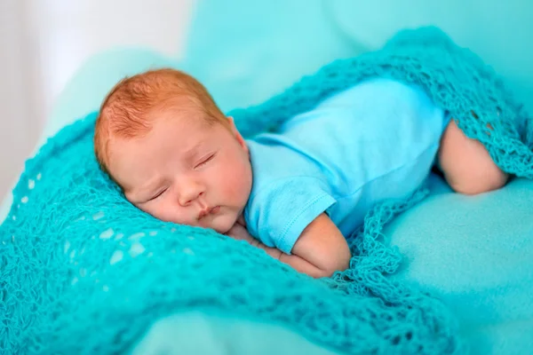 Ребенок спит на животе на синем одеяле — стоковое фото