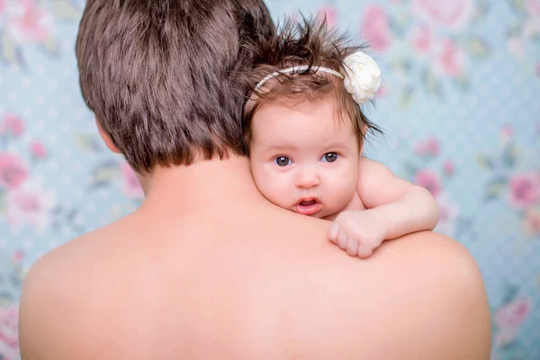 Little girl looks through a shoulder dad — Stock Photo, Image