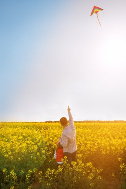 Baba ve kızı bir uçurtma batımında denize indirmek