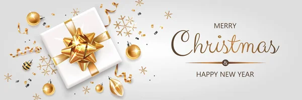 Üzerinde altın ve gümüş Noel sembolleri ve metin olan yatay bir pankart. Noel hediyeleri, dekorasyon ve ışık arka planındaki diğer şenlikli unsurlar.