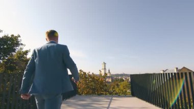 İş adamı hedefine doğru ilerler. Ceketli başarılı genç bir adam şehre geliyor..