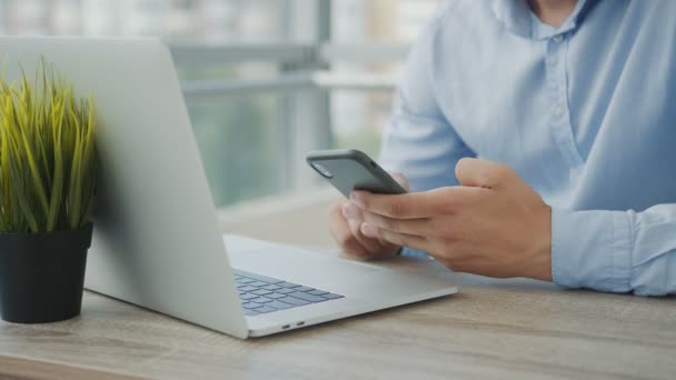 Ruce muže držícího mobilní telefon v rukou a používajícího přístroj k práci. Muž zblízka s mobilem v rukou. — Stock video